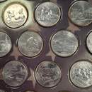 Set comprising an album of 49 U.S. state quarters plus 2  coin specimens.