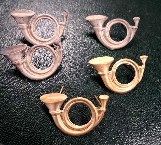 Hunting horns with the bell to the left, viewed from the front. Silver or gold.