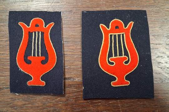 Musician's specialty badge. Red cut-out lyre, edged with gold thread, golden strings